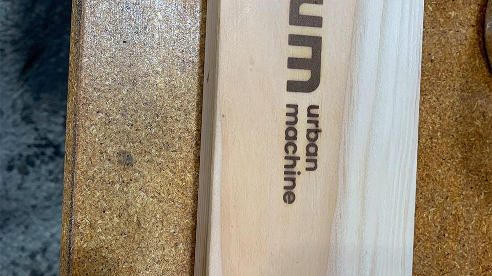Close up of Urban Machine "UM" brand burned into a plank of wood